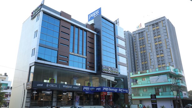 A hotel with a Pepsi sign, a Whirlpool store, and a sign for Elica. - Hotel 8th Mile Suites (Bengaluru)