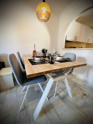 Un coin repas avec une table en bois, des chaises modernes et un luminaire suspendu.