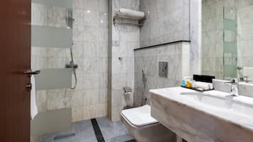 Un baño moderno con ducha, inodoro y lavamanos.