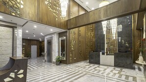 A spacious lobby with a marble floor, a reception desk, and a reception area with a large window. - Westin Mark Hotel (Madinah)