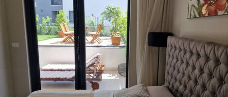 Ein Schlafzimmer mit Bett, Blick auf den Balkon und einem Gemälde an der Wand.