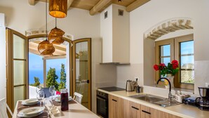 Una cocina moderna con una isla grande, horno integrado y vistas al mar.