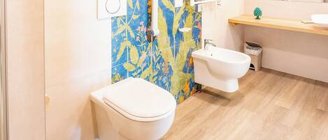 A bathroom with a toilet, bidet, and sink.