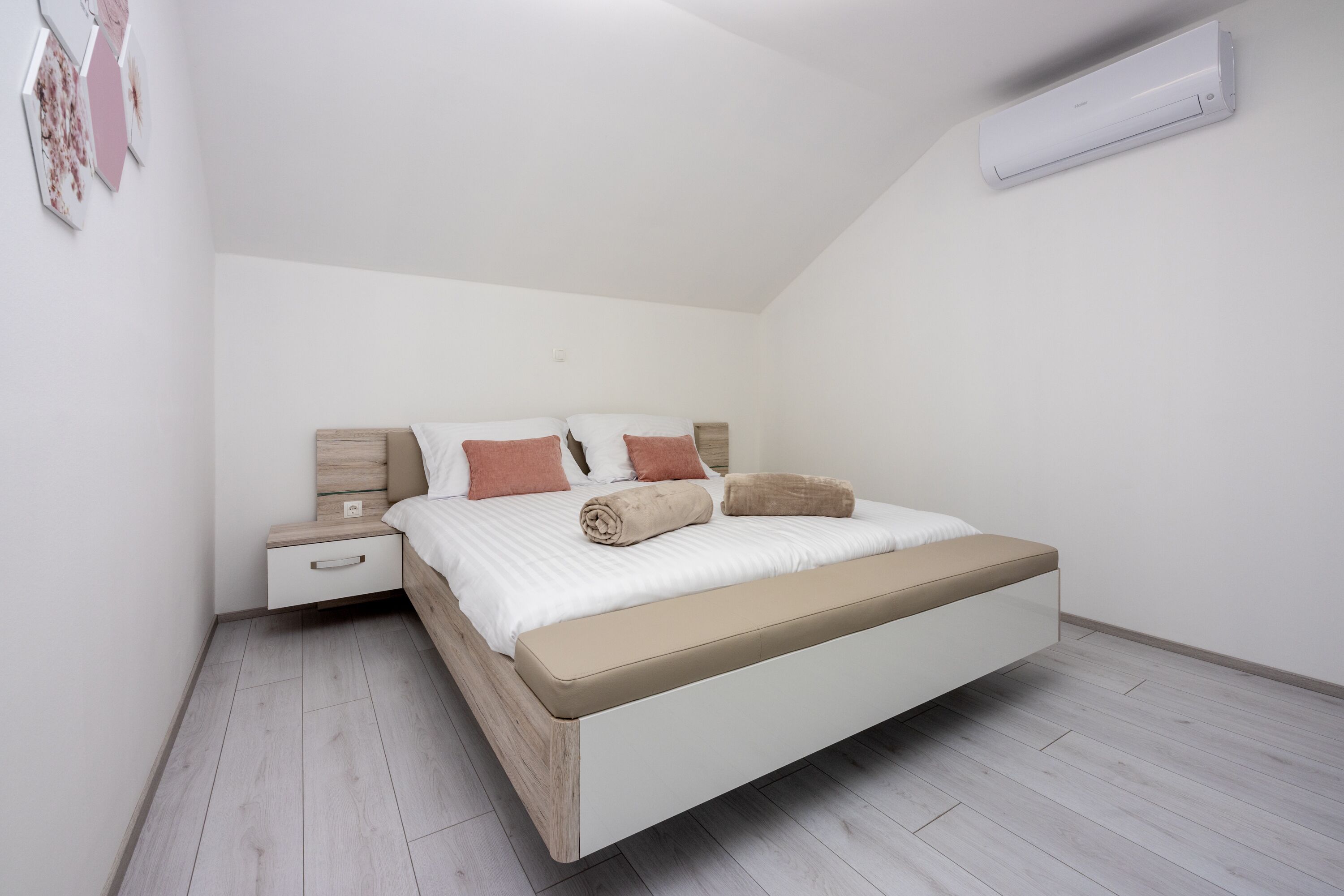 Un dormitorio moderno con cama, mesita de noche y almacenamiento integrado.