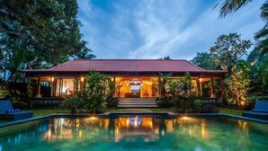 Ein Resort mit Schwimmbad, überdachter Terrasse und gut beleuchtetem Eingang.