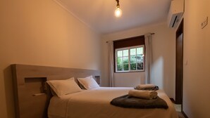 Ein Schlafzimmer mit Bett, Fenster und Klimaanlage.