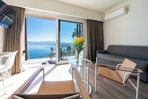 A balcony with a view of the sea, a sofa, a table with a vase, and a chair. - Hotel Belvedere Resort 4 stelle (Castellammare del Golfo)