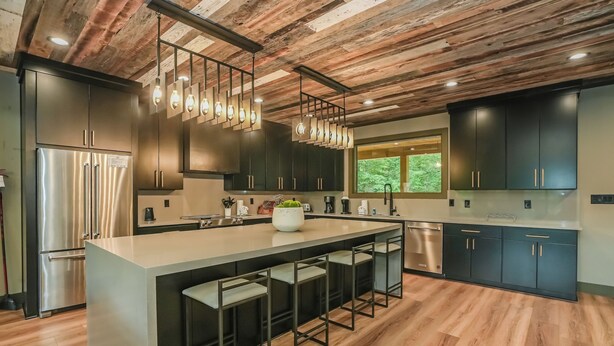 A modern kitchen with a large island, dark cabinetry, and a wooden ceiling. - MMMajesty: Pool, View, Secluded, Theater, Games, Hot Tub, WiFi, Yard, Fire Pit (Sevierville)