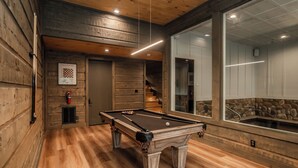 A pool table in a room with wooden walls and a stone accent wall. - MMMajesty: Pool, View, Secluded, Theater, Games, Hot Tub, WiFi, Yard, Fire Pit (Sevierville)