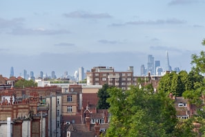 A cityscape with a mix of residential and commercial buildings, including a prominent skyscraper in the distance. - The Streatham Penthouse (London)