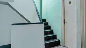 A staircase with black steps and green edges, leading to a door marked with the number 16. - Hotel O Home Stay Elis Cateliya Syariah (Karawang)