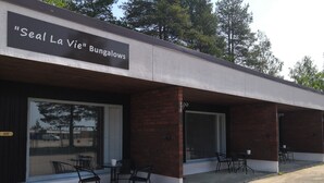 A building labeled "Seal La Vie" Bungalows with a covered patio area featuring outdoor seating. - Leikari Bungalows (Kotka)