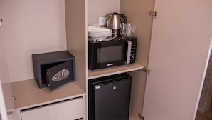 A compact kitchenette with a microwave, a small refrigerator, and a safe. - 262 Boutique Aliados (Porto)