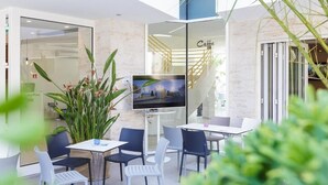 Un espacio interior moderno con zona de estar, televisor y escalera.