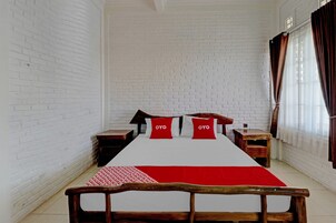 A room with a bed, white brick walls, and a window with curtains.