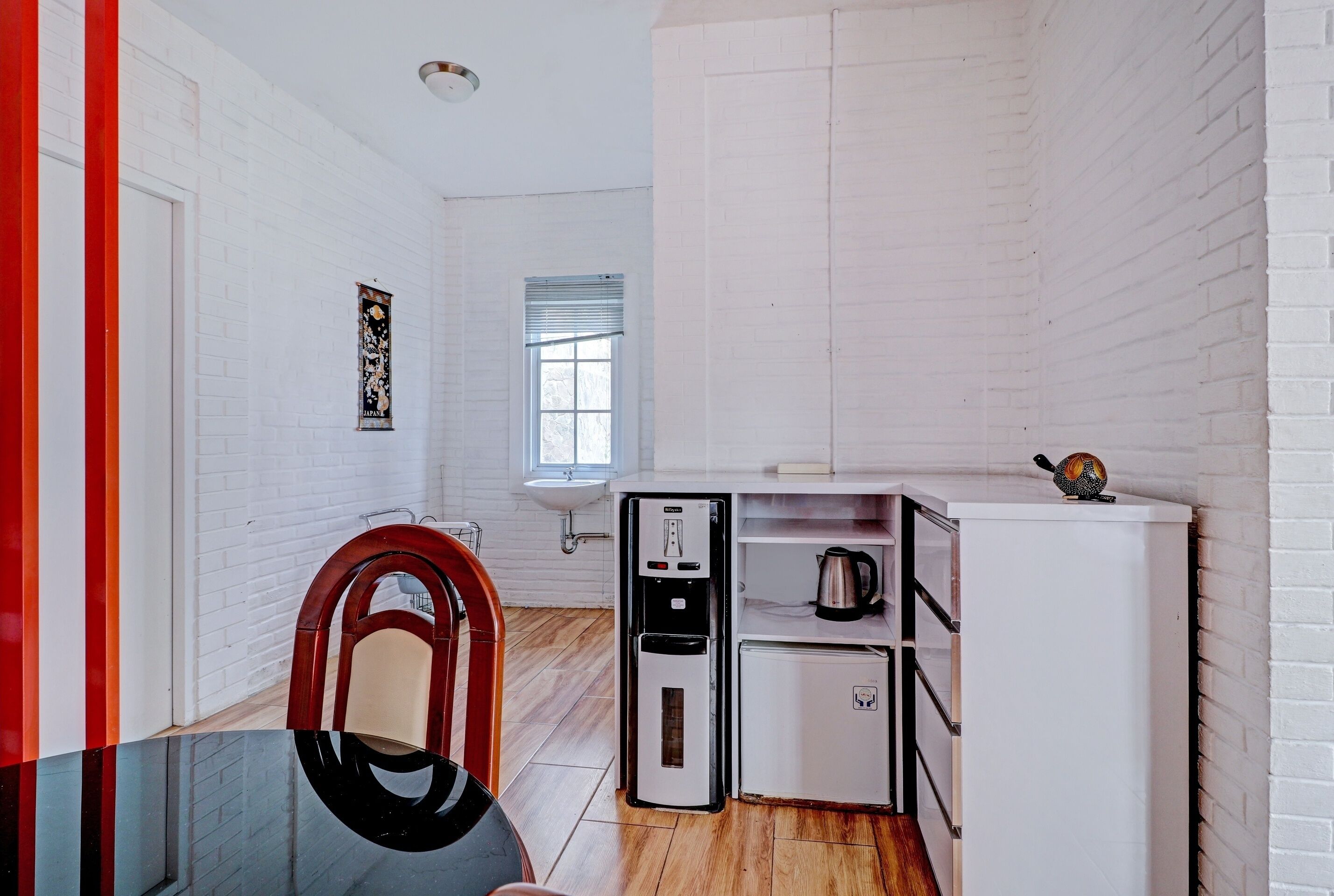 A compact kitchen with a refrigerator, sink, and a small cabinet.