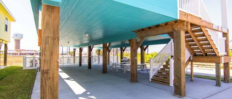 A covered outdoor area with picnic tables and a staircase.