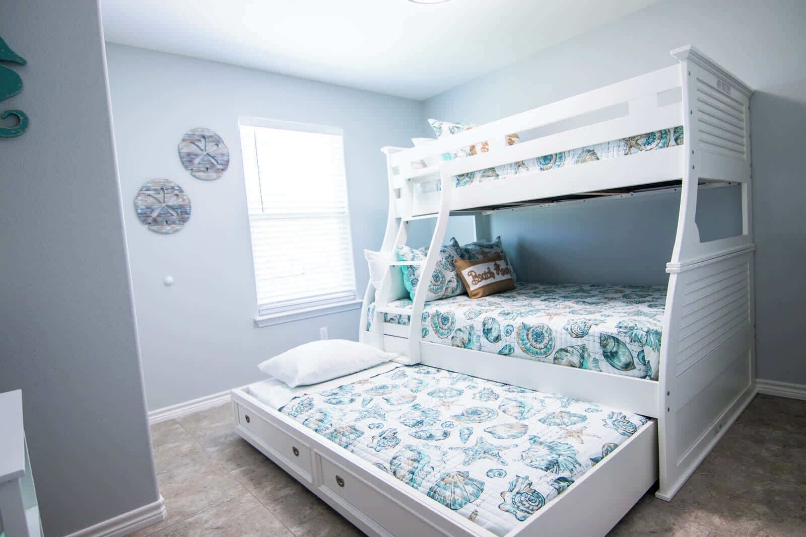 A bunk bed room with a window, a clock, and a small wall decoration.
