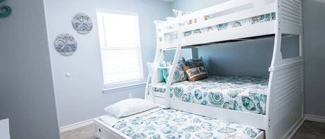 A bunk bed room with a window, a clock, and a small wall decoration.