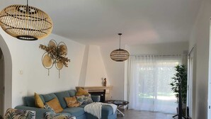 Una sala de estar con un sofá modular, una mesa de centro y un televisor sobre un mueble.