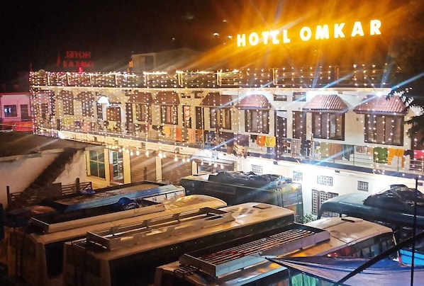 A hotel with multiple levels and balconies, featuring a prominent sign that reads "HOTEL OMKAR". - Hotel Omkaar and Restaurant (Chinyalisaur)