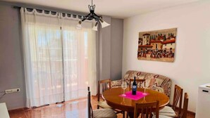 Un coin repas avec une table ronde, des chaises et un tableau accroché au mur.