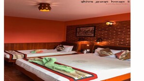 Habitación de hotel con dos camas, cabeceros de madera, una pared de ladrillo y una lámpara en el techo.