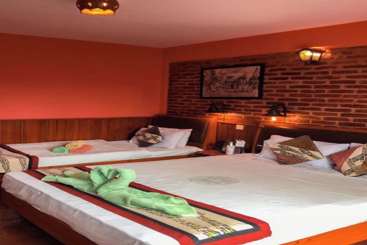 A hotel room with two beds, wooden headboards, a brick wall, and a ceiling light fixture.
