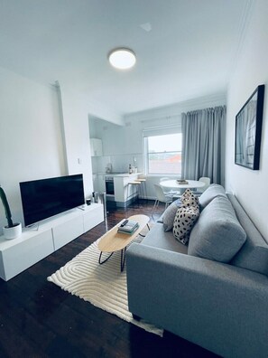Relax in this stylish living room with a flat-screen TV, comfortable sofa, and modern coffee table.