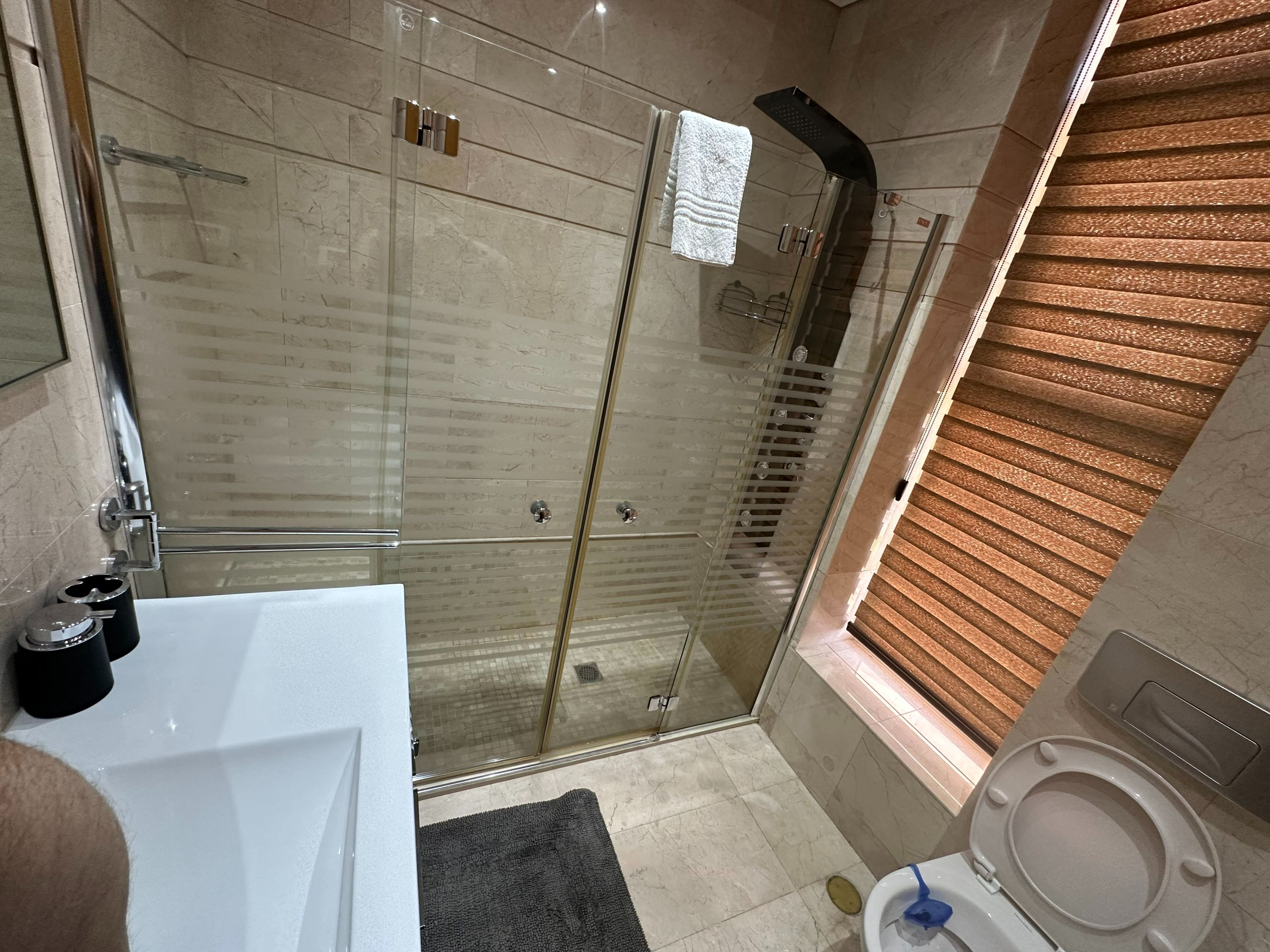 Ein modernes Badezimmer mit einer Duschkabine, einer weißen Badewanne und einer Toilette.