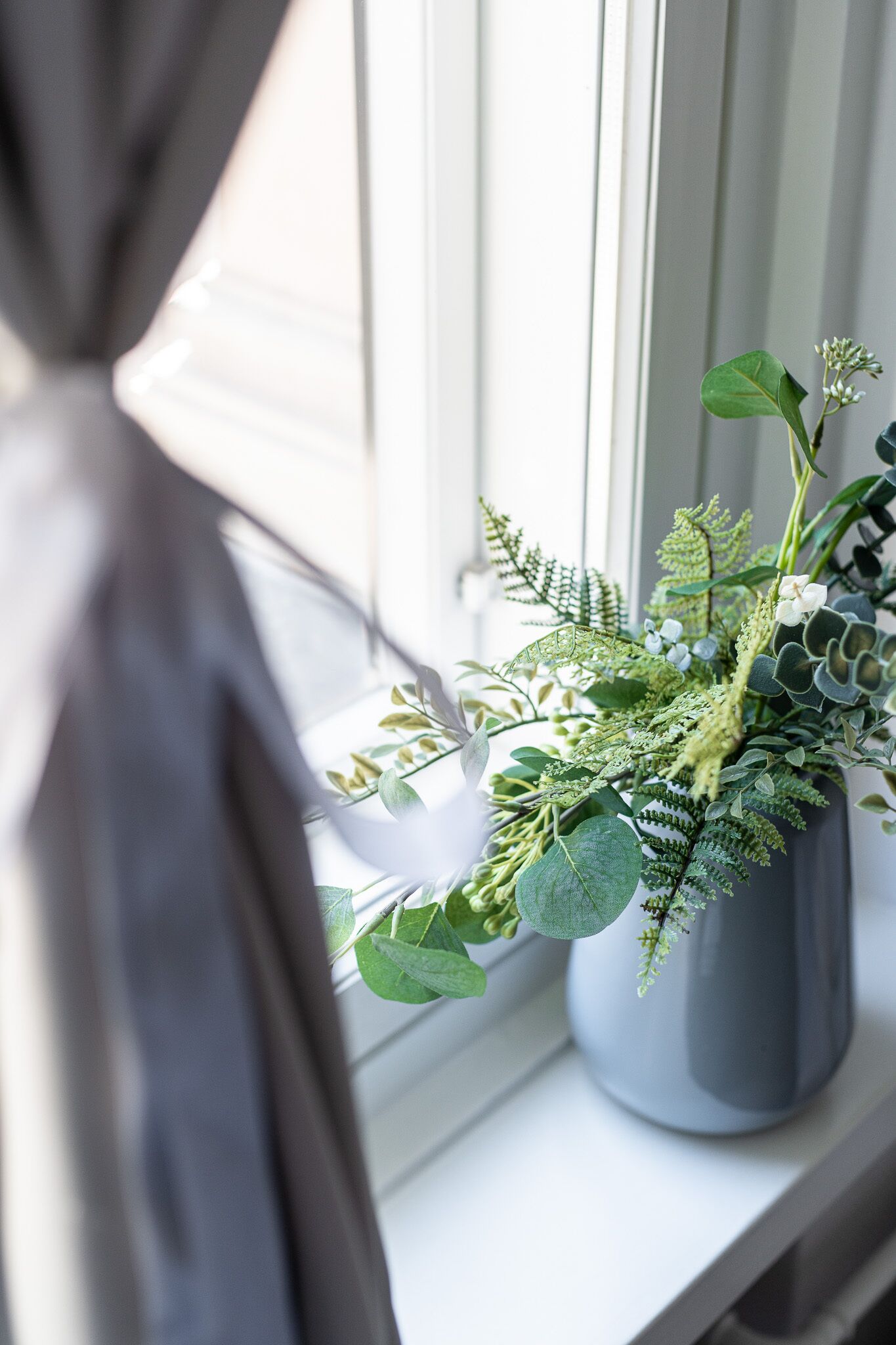 Une fenêtre avec un pot de fleurs posé sur le rebord.