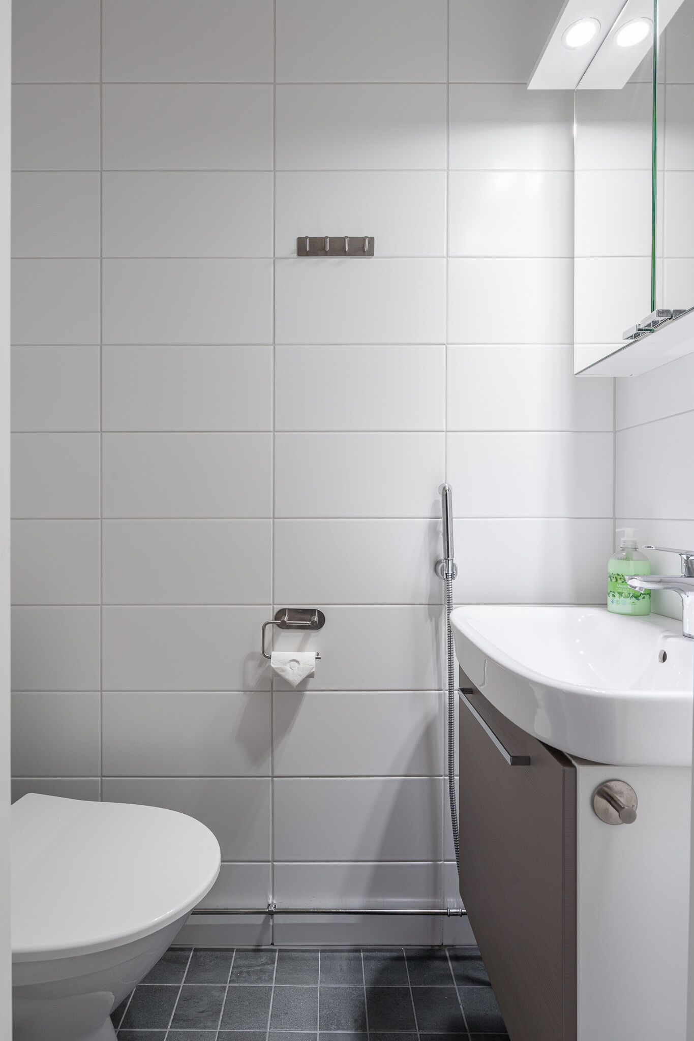 A modern bathroom with a toilet, shower, and sink.