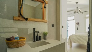 Une salle de bain avec un grand miroir, un lavabo et un porte-serviettes.