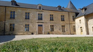 A historic stone building with multiple windows and a central entrance. - Château à 5mn des Sentiers (Charbogne)