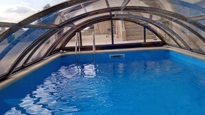 A swimming pool with a glass enclosure and a ladder. - Château à 5mn des Sentiers (Charbogne)