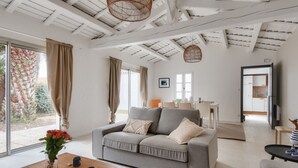 A modern living room with a grey sofa, a wooden coffee table, and a large window with curtains. - 8 adults - 2 kids - Salt marshes and beaches (Noirmoutier-en-l´Ile)