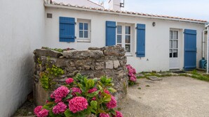 A white building with blue shutters and a stone wall. - 8 adults - 2 kids - Salt marshes and beaches (Noirmoutier-en-l´Ile)