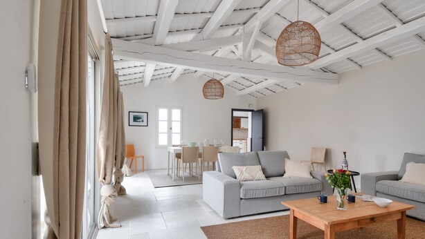 A modern living room with a wooden coffee table, two grey sofas, and a dining area in the background. - 8 adults - 2 kids - Salt marshes and beaches (Noirmoutier-en-l´Ile)