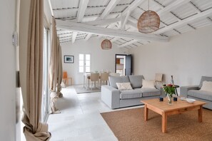 Un soggiorno moderno con un tavolino in legno, due divani grigi e un'area pranzo sullo sfondo.