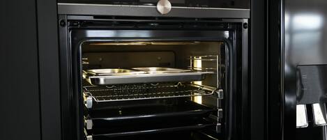An open oven with a digital clock displaying 13:00.