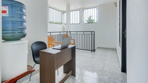 Habitación de hotel con escritorio, silla y dispensador de agua.