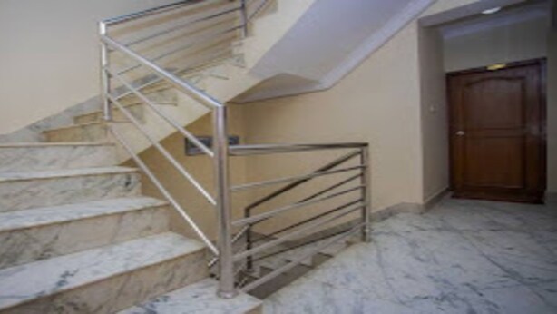 A marble staircase with metal railings leading to a landing. - MeroStay 165 HOTEL RI (Kathmandu)