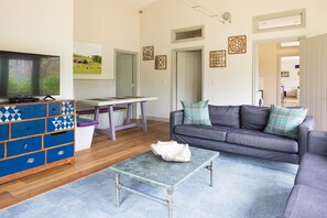 A living room with a television, sofa, coffee table, and a blue patterned dresser.