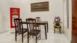 Un coin repas avec une table et des chaises en bois, une décoration murale et une affiche accrochée au mur.