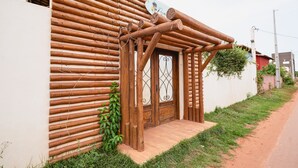 Une maison en bois avec une porte en bois et un petit porche.