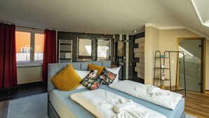 A modern hotel room with a large bed, a glass door leading to a balcony, and a wooden floor. - Hotel Tanne (Ilmenau)