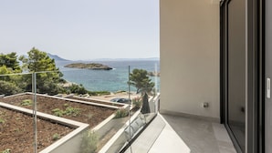 A balcony with a view of the sea and a distant island. - Villa Luce (Pijavicino)