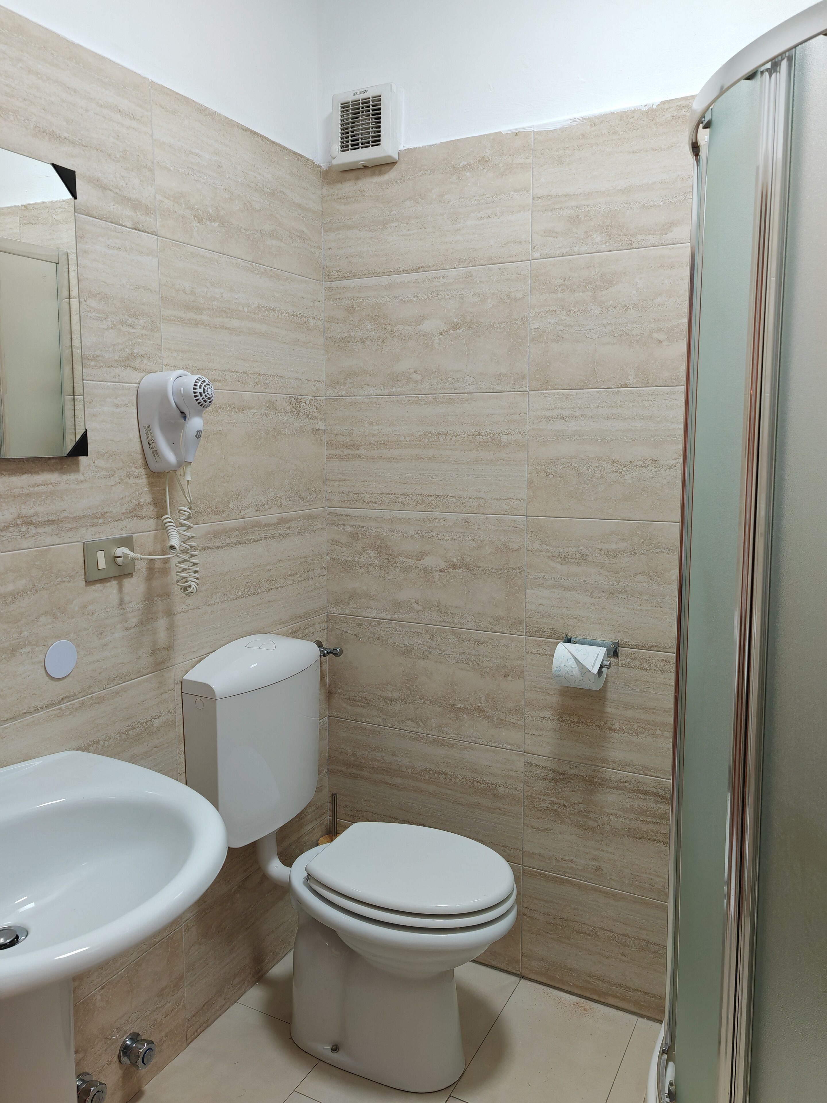 Ein Badezimmer mit Toilette, Waschbecken und Dusche.