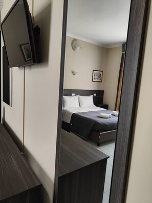 A hotel room with a bed, a bedside table, a wall-mounted TV, and a framed picture on the wall. - Hotel Romano (Turin)