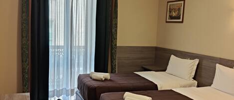 Une chambre d’hôtel avec deux lits, un bureau et une chaise.